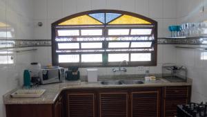 a kitchen with a sink and a window at Casa Itaguá in Ubatuba +14 photos