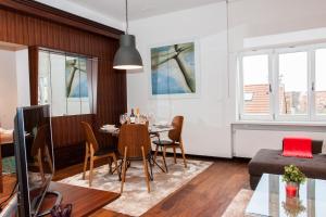 a dining room and living room with a table and chairs at Centroom Apartment Zagreb in Zagreb