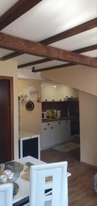 a kitchen with a table and a kitchen with white cabinets at Къща за гости ОЗИ 3 in Ovchartsi