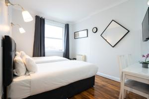 a hotel room with two beds and a window at MSK Hotel 82 in London +34 photos