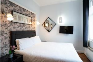 a bedroom with a white bed and a mirror at MSK Hotel 82 in London