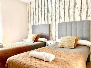 a bedroom with two beds with trees on the wall at cultura y playa in Puerto de Sagunto