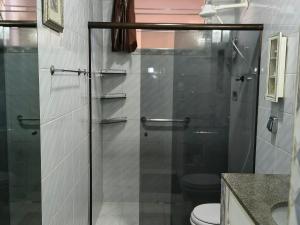 a bathroom with a glass shower with a toilet at Casa Da Vovó Helena in Vila Velha