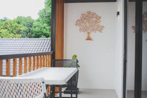 a porch with a white table and a tree on the wall at Treehouse Executive Villas - ANGELES in Malino