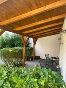 a wooden pergola with chairs and tables on a patio at Na domečku in Bořetice +4 photos