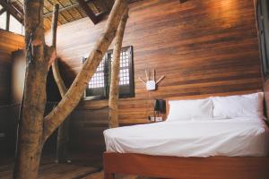 a bedroom with a bed in a wooden wall at Treehouse Executive Villas - ANGELES in Malino +64 photos
