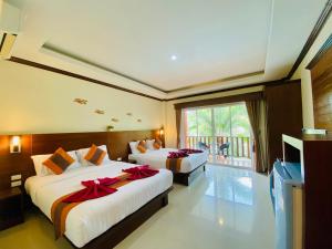 a bedroom with two beds with red bows on them at Peaceful Resort , Long Beach - Koh Lanta in Ko Lanta +84 photos