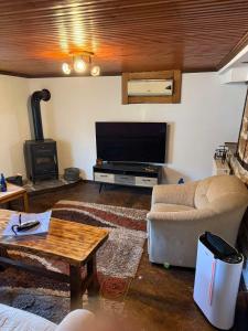 a living room with a couch and a flat screen tv at Lithos Home in Panagia