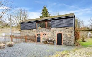 a small brick house with a black roof at Gîte de la chapelle in Houffalize