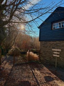 a house with a wooden gate in front of it at Gîte de la chapelle in Houffalize +2 photos