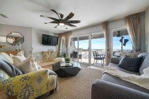 a living room with a couch and a ceiling fan at Twin Palms - Beachfront Duplex with Ocean Views & Direct Beach Access in Destin