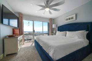 a bedroom with a blue bed and a large window at Twin Palms - Beachfront Duplex with Ocean Views & Direct Beach Access in Destin