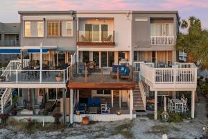 a large house with a deck on the beach at Twin Palms - Beachfront Duplex with Ocean Views & Direct Beach Access in Destin