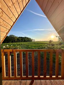 a view from a deck at sunset at Tiny house in Saint-Rémy-Boscrocourt