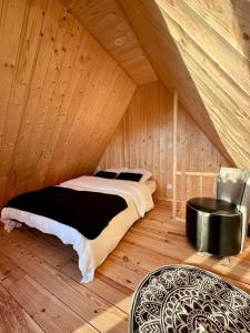 a bedroom with a bed in a wooden room at Tiny house in Saint-Rémy-Boscrocourt