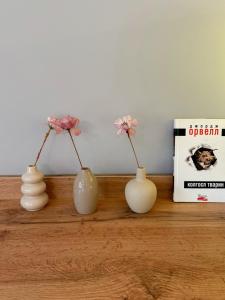 four vases sitting on a shelf with flowers in them at Hygge Apartment in Mizhhirya +31 photos