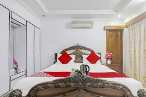 a bedroom with a large bed with red pillows at Super Hotel O Alpine Glow Crest in Hyderabad