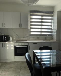 a kitchen with a stove and a table with chairs at Rix Hostel Oda Kiralama, Ortak Banyo Mutfak in Kyrenia