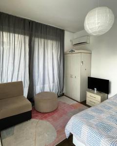 a bedroom with a bed and a chair and a television at Rix Hostel Oda Kiralama, Ortak Banyo Mutfak in Kyrenia