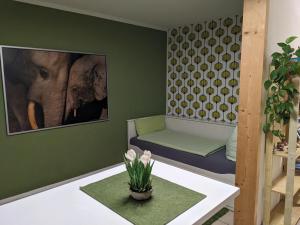 a green room with a couch and an elephant on the wall at 20qmchemnitz in Chemnitz