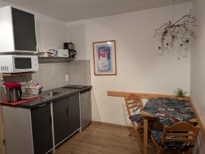 a small kitchen with a table and a microwave at 20qmchemnitz in Chemnitz
