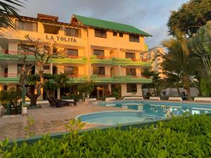 a hotel with a swimming pool in front of a building at Hotel La Tolita in Atacames +24 photos