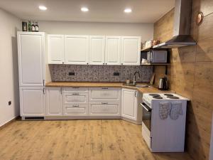 a kitchen with white cabinets and a stove top oven at Chalupa u dědy in Kozlov