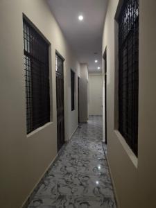 a hallway with a tile floor and two windows at Yamuna Bank Inn in Prayagraj +1 photo