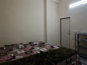 a bedroom with a bed with a green blanket at Yamuna Bank Inn in Prayagraj