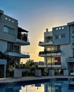 a view of two apartment buildings with a swimming pool at Rix Hostel Oda Kiralama, Ortak Banyo Mutfak in Kyrenia