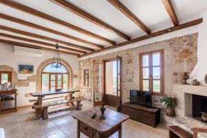 a living room with a fireplace and a table at Tzokeika Traditional Settlement in Riglia