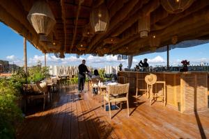 a wooden deck with a bar with tables and chairs at Almaha Marrakech Restaurant & SPA in Marrakesh