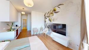 a bedroom with a bed and a kitchen with a fireplace at Apartment FreshOlive in Trnávka