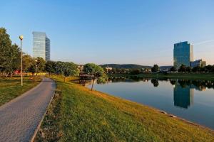 a path next to a body of water with buildings at Apartment FreshOlive in Trnávka