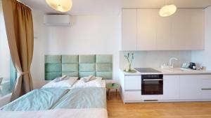 a bedroom with a bed and a sink and a kitchen at Apartment FreshOlive in Trnávka