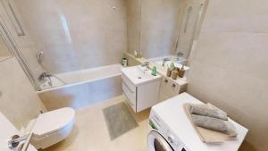 a bathroom with a toilet sink and a washing machine at Apartment FreshOlive in Trnávka +11 photos