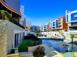 an apartment complex with a swimming pool and buildings at La Mirada New Cairo in Cairo