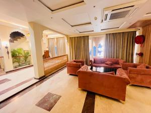 a living room with couches and a table and chairs at Grove Residency Huaz Khas New Delhi - Couple Friendly in New Delhi