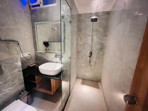 a bathroom with a glass shower and a sink at Grove Residency Huaz Khas New Delhi - Couple Friendly in New Delhi