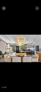 a living room with a chandelier and a dining room at Beach House Living in Gordonʼs Bay
