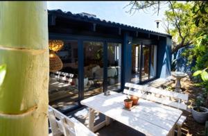 a small house with a table in front of it at Beach House Living in Gordonʼs Bay