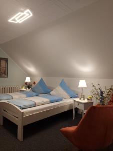 a room with two beds with blue pillows at Pension Renate Braun in Gamstädt