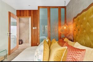 a bedroom with a large bed with pillows on it at Beach House Living in Gordonʼs Bay