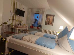 a bedroom with a large bed with blue pillows at Pension Renate Braun in Gamstädt
