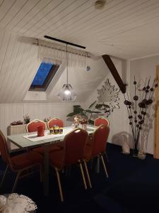 a dining room with a table and red chairs at Pension Renate Braun in Gamstädt