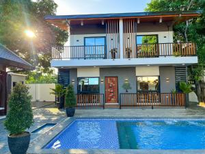a house with a swimming pool in front of a house at Treehouse Executive Villas - ANGELES in Malino