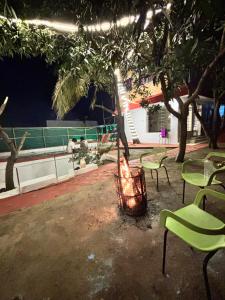 a fire pit in a yard with chairs and a tree at Happy Hills in Yelagiri