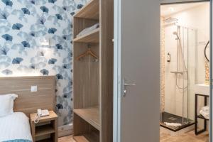 a bedroom with a bed and a shower at The Originals City, Hôtel Les Océanes, Lorient in Lorient +55 photos