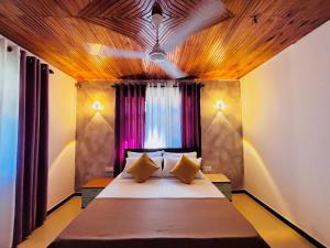 a bedroom with a large bed with two pillows at Luna Fortuna Villa in Tangalle