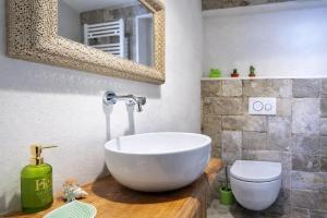 a bathroom with a white bowl sink and a toilet at Hotiday Polignano Centro - Fico d'India in Polignano a Mare